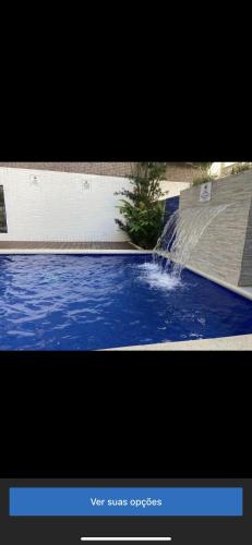 a picture of a swimming pool with a water fountain at Apartamento com varanda in Guarujá