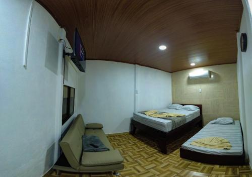 ein kleines Zimmer mit 2 Betten und einem Stuhl in der Unterkunft Tortuguero7 lake view in Tortuguero