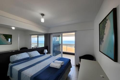 a bedroom with a bed and a view of the ocean at Vista Mar Apartamento em Armação in Salvador