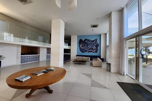 a living room with a wooden table and a couch at Vista Mar Apartamento em Armação in Salvador