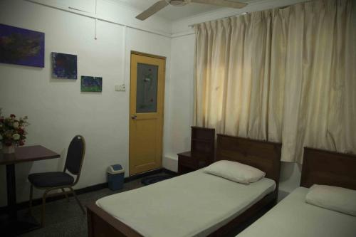 a bedroom with two beds and a desk and a chair at Lodge in 611 in Kandy