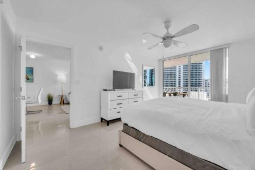 a white bedroom with a bed and a ceiling fan at Luxe 1 BDR •Brickell• Ocean View in Miami