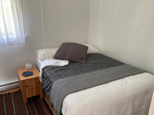 a small bedroom with a bed and a wooden table at Rent My Studio in Powell River