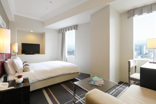 a hotel room with a bed and a tv at Hotel Nikko Kanazawa in Kanazawa