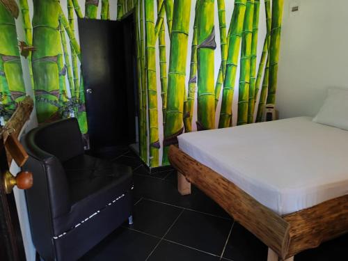 a bedroom with a bed and a chair and bamboo curtain at Alojamiento Rural Altos del Molino in Los Andes