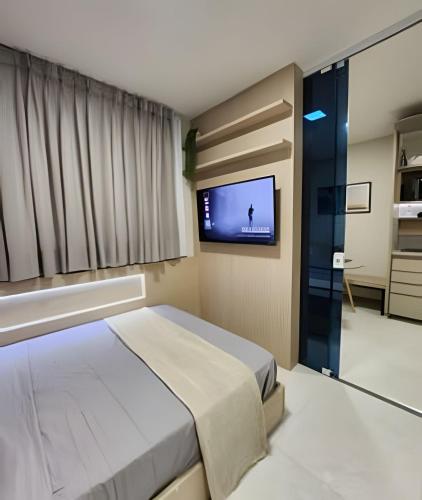 um quarto com uma cama e uma televisão de ecrã plano em Novissimo Apt Salvador em Salvador