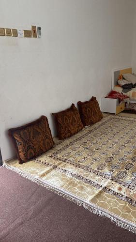 un letto con quattro cuscini sopra in una stanza di بيت للإيجار اليومي / House for daily rent a Al Bulaydah
