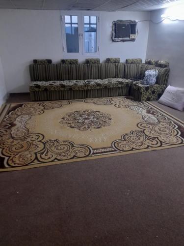 un soggiorno con divano e tappeto di بيت للإيجار اليومي / House for daily rent a Al Bulaydah
