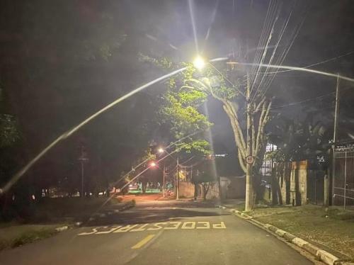 una calle vacía por la noche con un semáforo en Suíte Proença en Campinas
