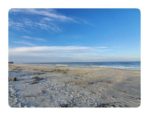 a sandy beach with the ocean in the background at Beach condo on Harbor Island,SC E105 in Oceanmarsh Subdivision