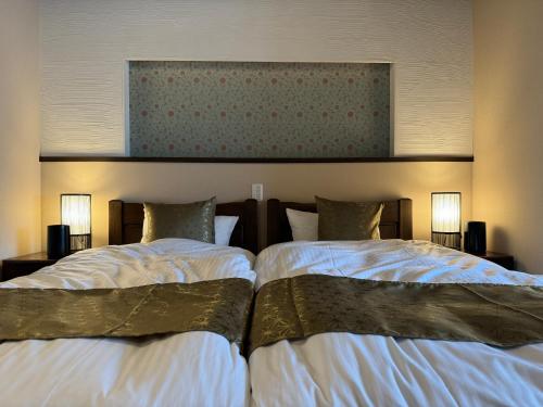 duas camas sentadas uma ao lado da outra num quarto de hotel em 京都駅そばの一棟貸し京町家 suiten shichijo 萃点七条 em Quioto