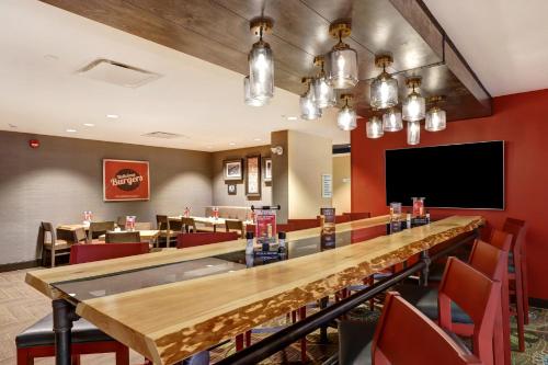 a long table in a restaurant with a television at Holiday Inn - Mississauga Toronto West by IHG in Mississauga