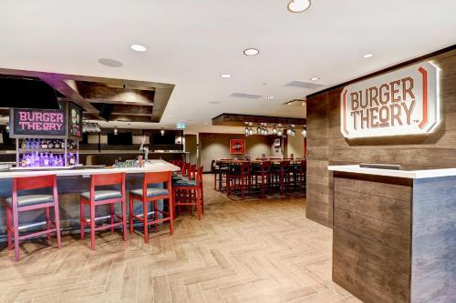 a burger theory restaurant with a bar and bar stools at Holiday Inn - Mississauga Toronto West by IHG in Mississauga