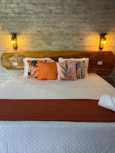 1 dormitorio con 1 cama grande con almohadas en Chalé Recanto das Estrelas en Monte Verde
