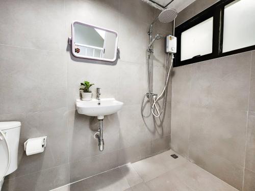 a bathroom with a sink and a shower at Noir Cafe And Hostel Chinatown Bangkok in Pom Prap
