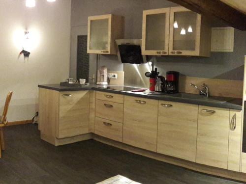 une cuisine avec des armoires en bois et un évier dans l'établissement Charmant appartement aux Gets, près des pistes, 4 pers, parking, TV, lave-vaisselle, navette à 10m - FR-1-671-145, aux Gets