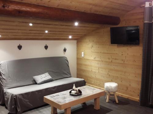 une chambre avec un lit et une télévision sur un mur dans l'établissement Charmant appartement aux Gets, près des pistes, 4 pers, parking, TV, lave-vaisselle, navette à 10m - FR-1-671-145, aux Gets