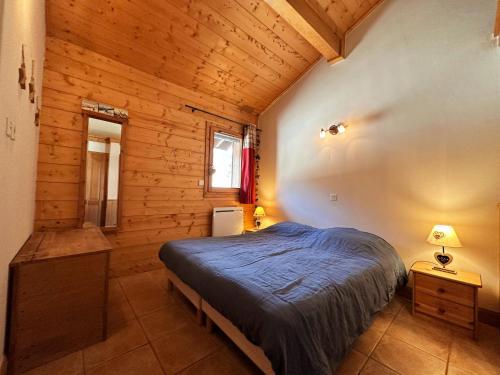 een slaapkamer met een bed in een houten hut bij Appartement Samoëns, 3 pièces, 6 personnes - FR-1-624-158 in Samoëns