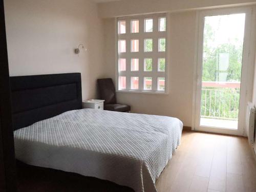 une chambre avec un lit et une grande fenêtre dans l'établissement Appartement familial en hyper centre de Royan, 6/8 pers, ascenseur - FR-1-494-180, à Royan