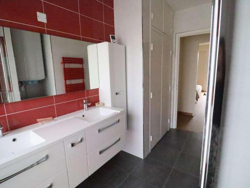 une salle de bain avec un lavabo blanc et un miroir dans l'établissement Appartement familial en hyper centre de Royan, 6/8 pers, ascenseur - FR-1-494-180, à Royan