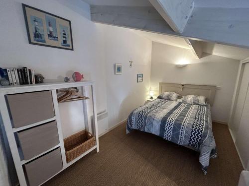 une chambre avec un lit et une étagère dans l'établissement Petite maison proche de l'océan avec piscine chauffée, jardin privé et parking - St Hilaire de Riez - FR-1-224C-292, à Saint-Hilaire-de-Riez