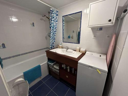 une petite salle de bain avec un lavabo et une baignoire dans l'établissement Petite maison proche de l'océan avec piscine chauffée, jardin privé et parking - St Hilaire de Riez - FR-1-224C-292, à Saint-Hilaire-de-Riez