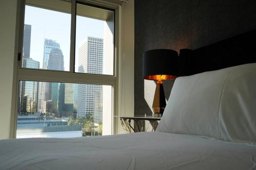 a bedroom with a white bed and a large window at Downtown LA - Mamba Suite - Free Indoor Parking! in Los Angeles