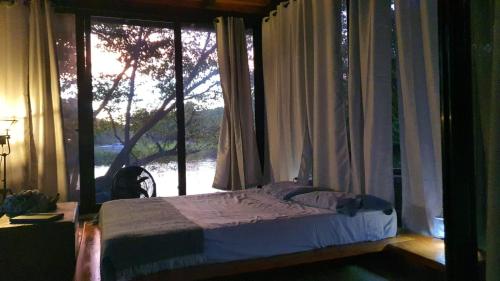 1 dormitorio con 1 cama frente a una ventana en Isla Mirabel, a unique private island experience!, en Granada
