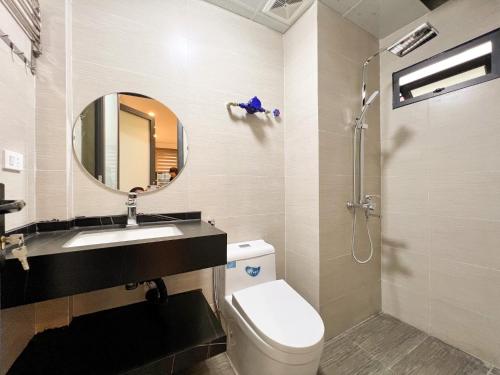 a bathroom with a toilet and a sink and a mirror at NINE HOUSING 290 Kim Ma in Hanoi