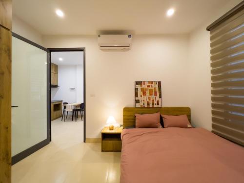 a bedroom with a bed and a table with a lamp at NINE HOUSING 290 Kim Ma in Hanoi