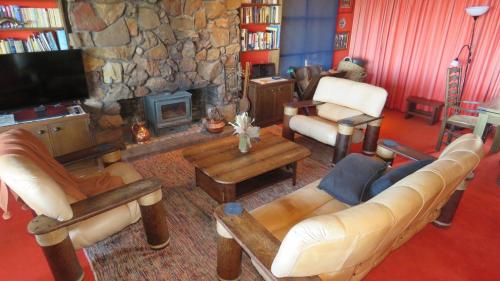 a living room with a couch and a stone fireplace at Moonya Lodge in Mount Victoria