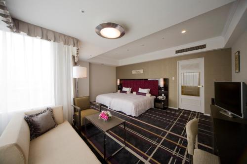 a hotel room with a bed and a couch at Hotel Nikko Kanazawa in Kanazawa