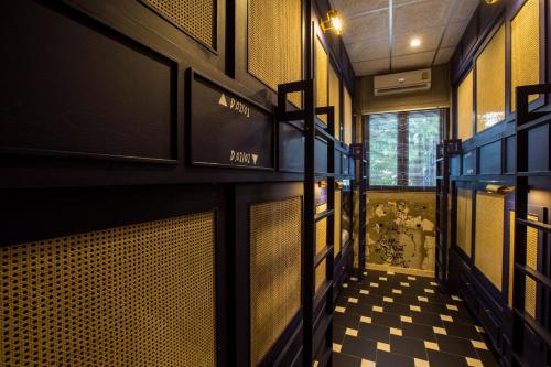 a hallway of a restaurant with a checkered floor at Azure Hostel Bangkok in Bangkok
