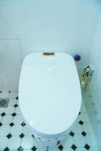 a white toilet in a bathroom with a blue light at HANA Stay in Hanoi