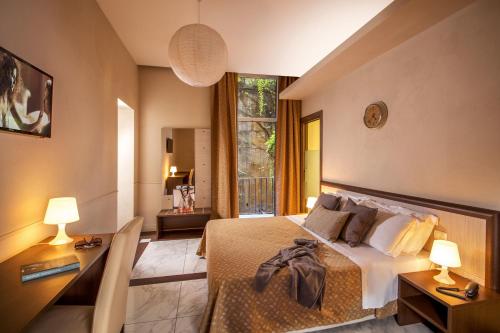 - une chambre avec un grand lit et une fenêtre dans l'établissement Corso Grand Suite, à Rome