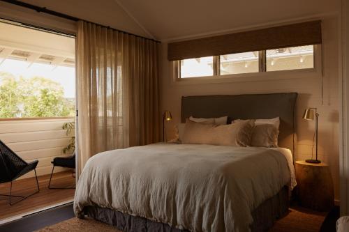Un dormitorio con una cama grande y una ventana en 28 Degrees Byron Bay - Adults Only, en Byron Bay