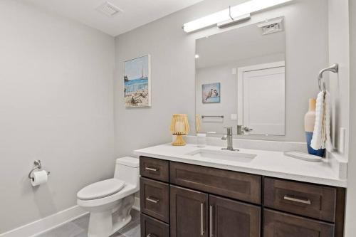 ein Badezimmer mit einem Waschbecken, einem WC und einem Spiegel in der Unterkunft NEW Lakeview Condo with Hot Tub and Pool in Canandaigua