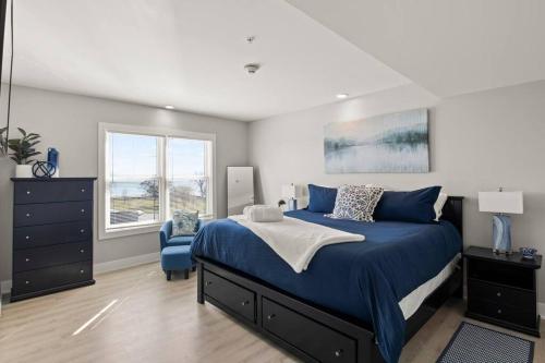 ein Schlafzimmer mit einem blauen Bett und einem blauen Stuhl in der Unterkunft NEW Lakeview Condo with Hot Tub and Pool in Canandaigua