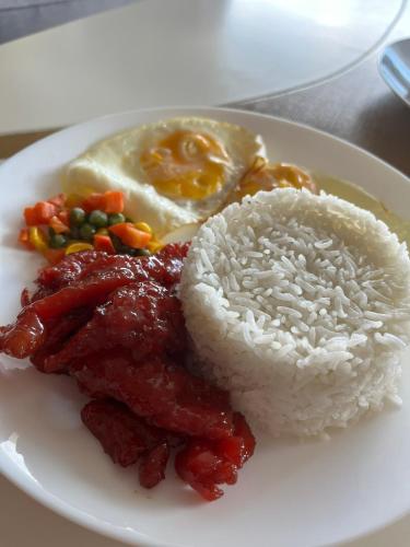 a white plate of food with rice and meat at AEON SUITES Staycation in Davao City