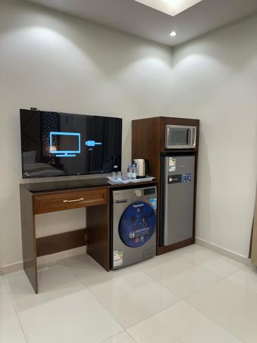 a room with a computer desk and a dishwasher at شقق جيهان الخاصة in Medina