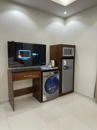 a room with a computer desk and a dishwasher at شقق جيهان الخاصة in Al Madinah