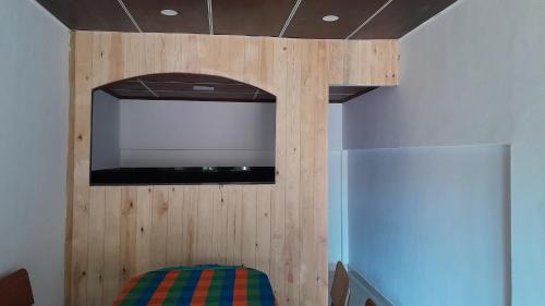 a room with a tv on the wall and a refrigerator at Vidatha Villa in Bandarawela