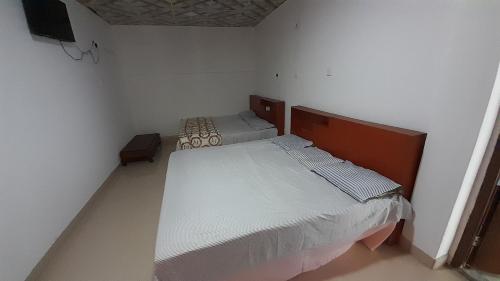 two beds in a small room with white walls at Vidatha Villa in Bandarawela