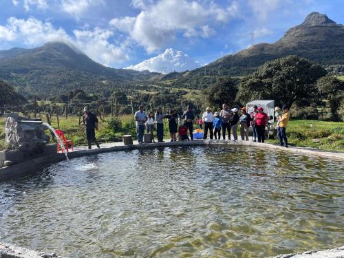 a group of people standing around a pool of water at Quinde Ñan Lodge in Papallacta