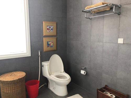a bathroom with a toilet and a red trash can at Villa Sea Links ( Biệt Thự nghỉ dưỡng ) in Ấp Phú Tịnh (2)