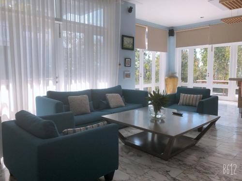 a living room with blue couches and a coffee table at Villa Sea Links ( Biệt Thự nghỉ dưỡng ) in Ấp Phú Tịnh (2)