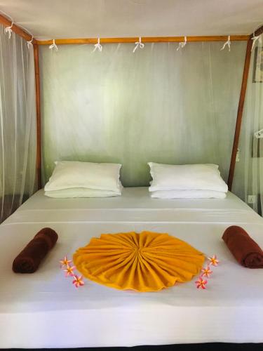 a bed with an orange dress on top of it at Turtle Eco Beach in Matara