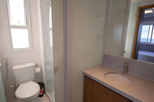 een badkamer met een toilet, een wastafel en een spiegel bij Novo Apt. 2 Quartos Vista Mar Salvador in Salvador