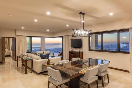 a dining room and living room with a view of the ocean at Beachfront 2 Bdrm Condo in Exclusive Diamante Golf in Cabo San Lucas