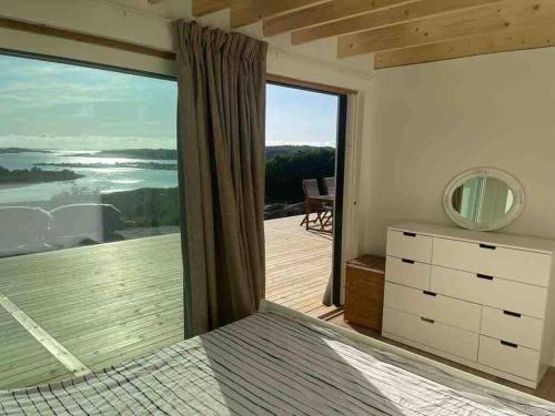 a bedroom with a view of a deck with a large window at Sea side villa with breathtaking view in Gothenburg